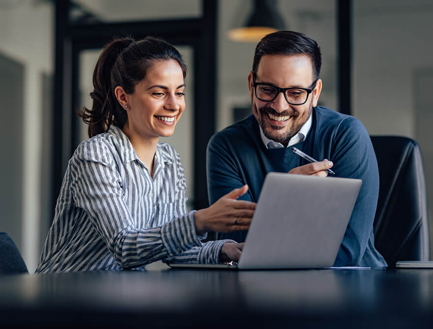 smiling business people looking at something over the laptop