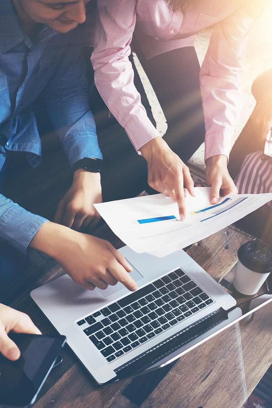 people working on a project together comparing data on computer